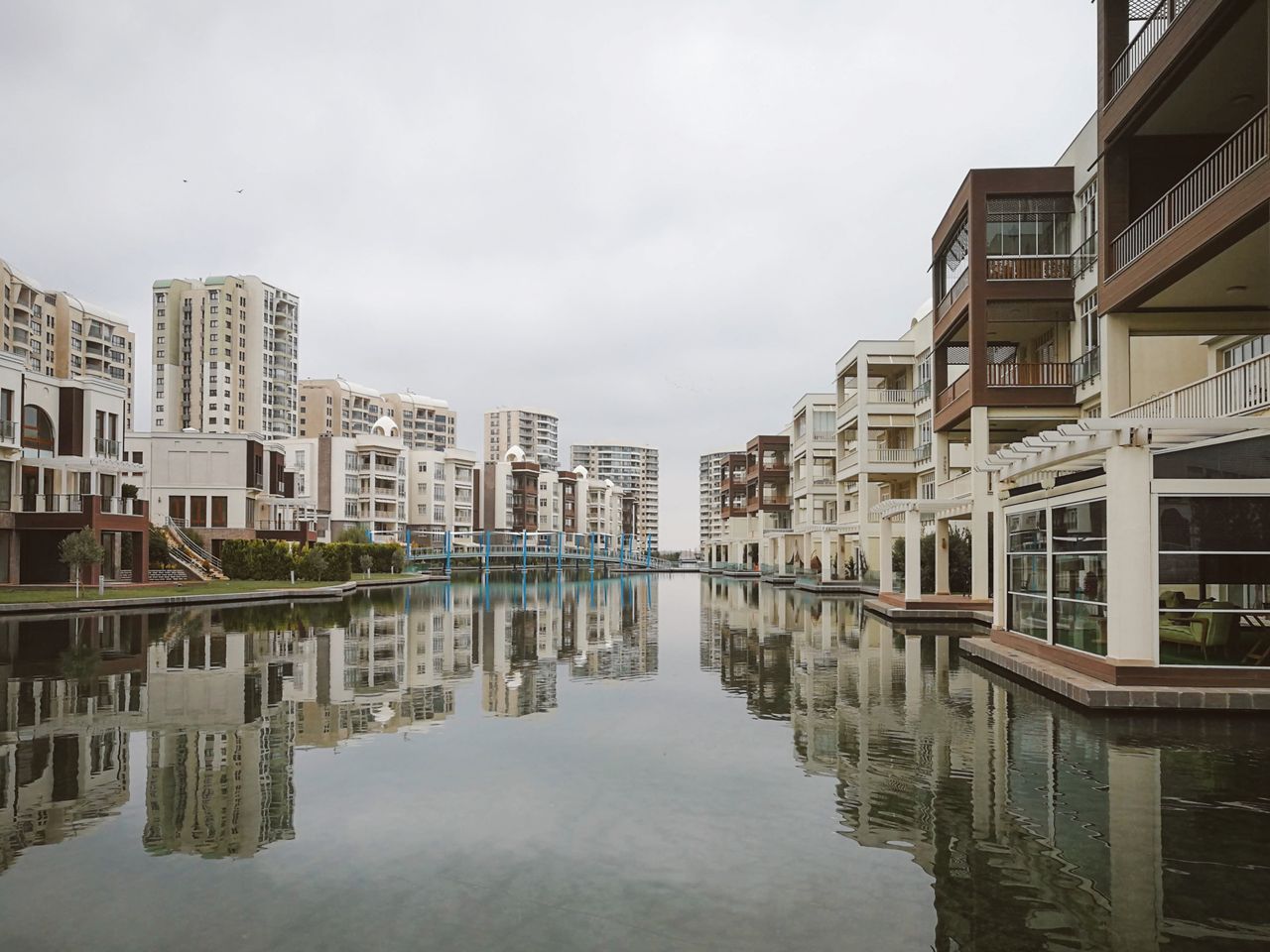 Home Modern residential buildings reflecting in a tranquil urban canal.